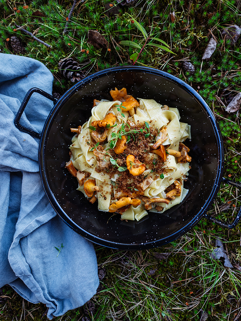Topf mit Pasta und Pfifferlingen auf Moos
